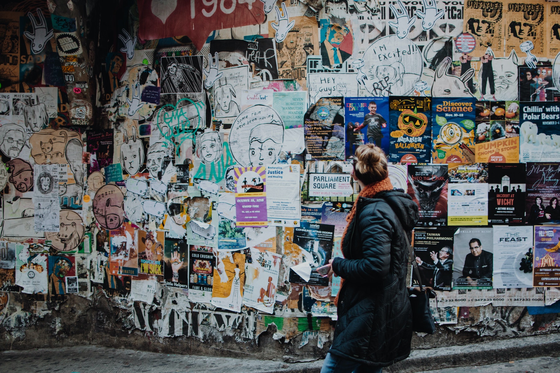 woman looking at hundreds of ads on a wall