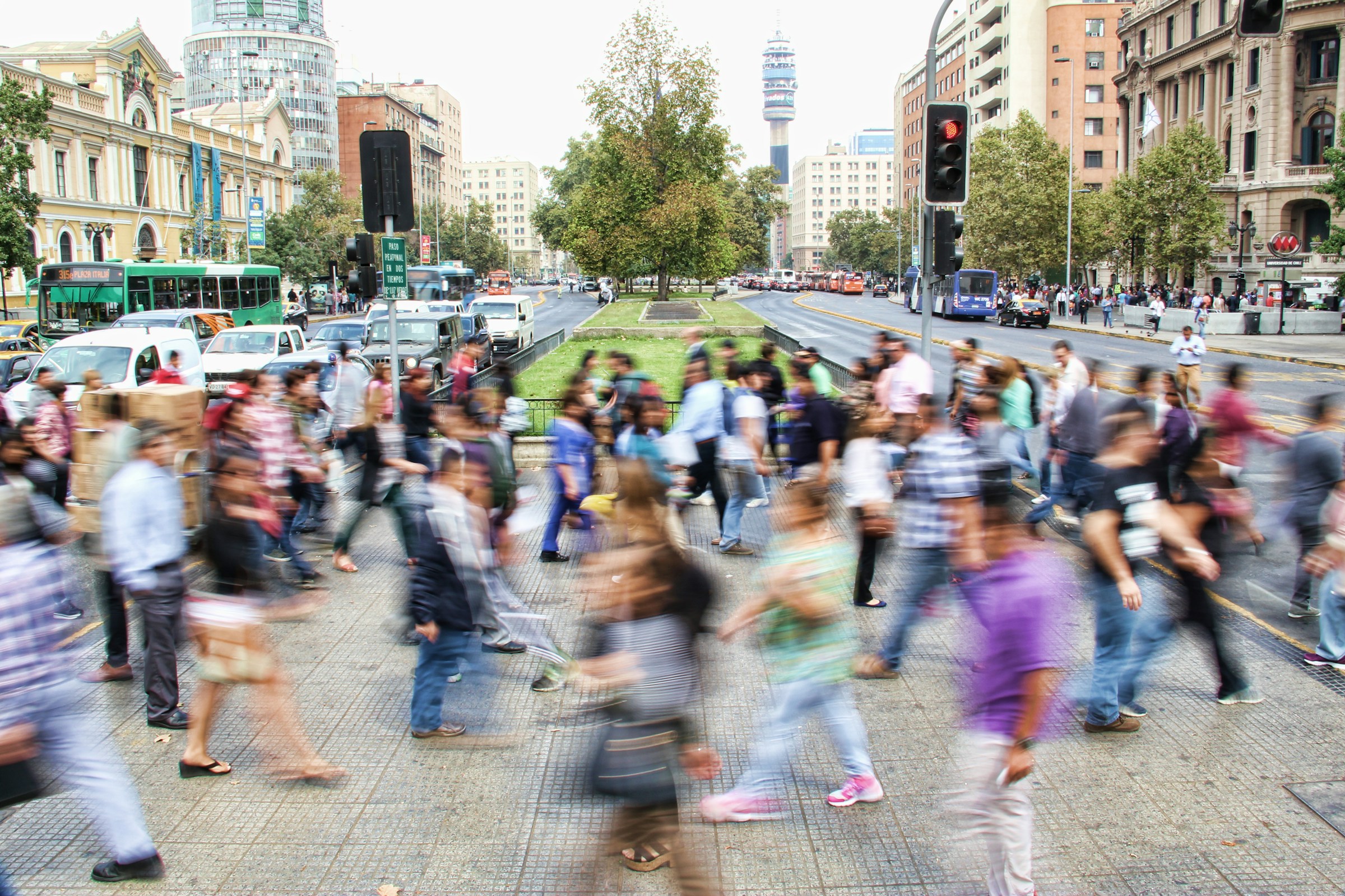 Blurred image of people walking through a cityscape 