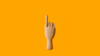 A wooden mannequin hand pointing up