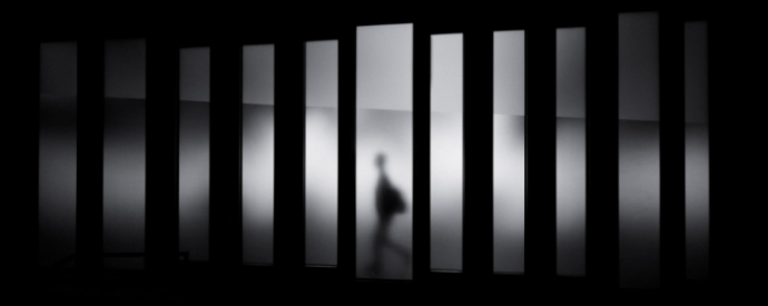 Man walking behind bars