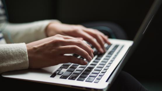 image of someone typing on laptop