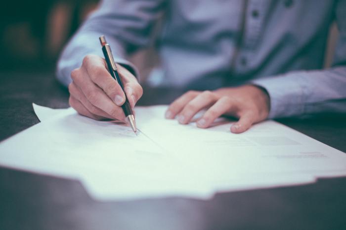 Man writting on paper on a desk