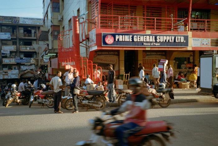 A group of BodaBoda drivers wait for customers outside a shop in Kampala