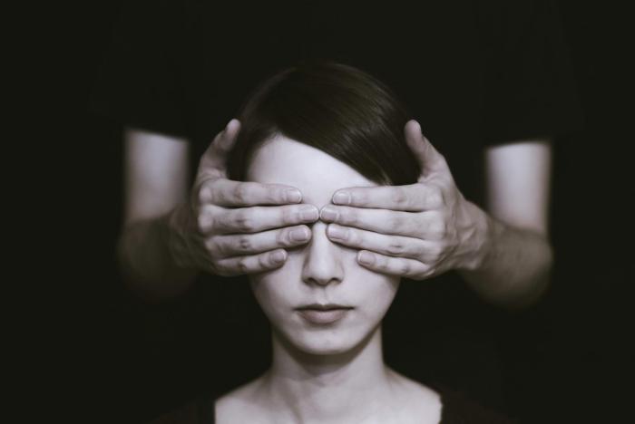 A woman with someone else's hands covering her eyes