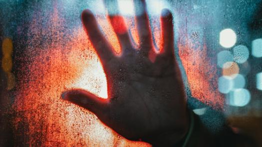 Hand on window in red and blue
