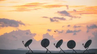 Satellite dishes against sunset background