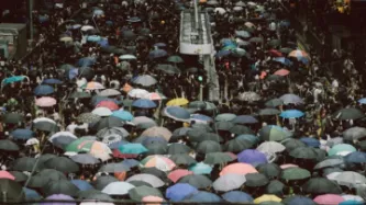 Crowds using umbrellas