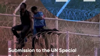 Two people sitting on a border fence