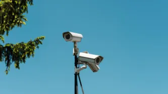 Tripod with surveillance cameras on blue sky background